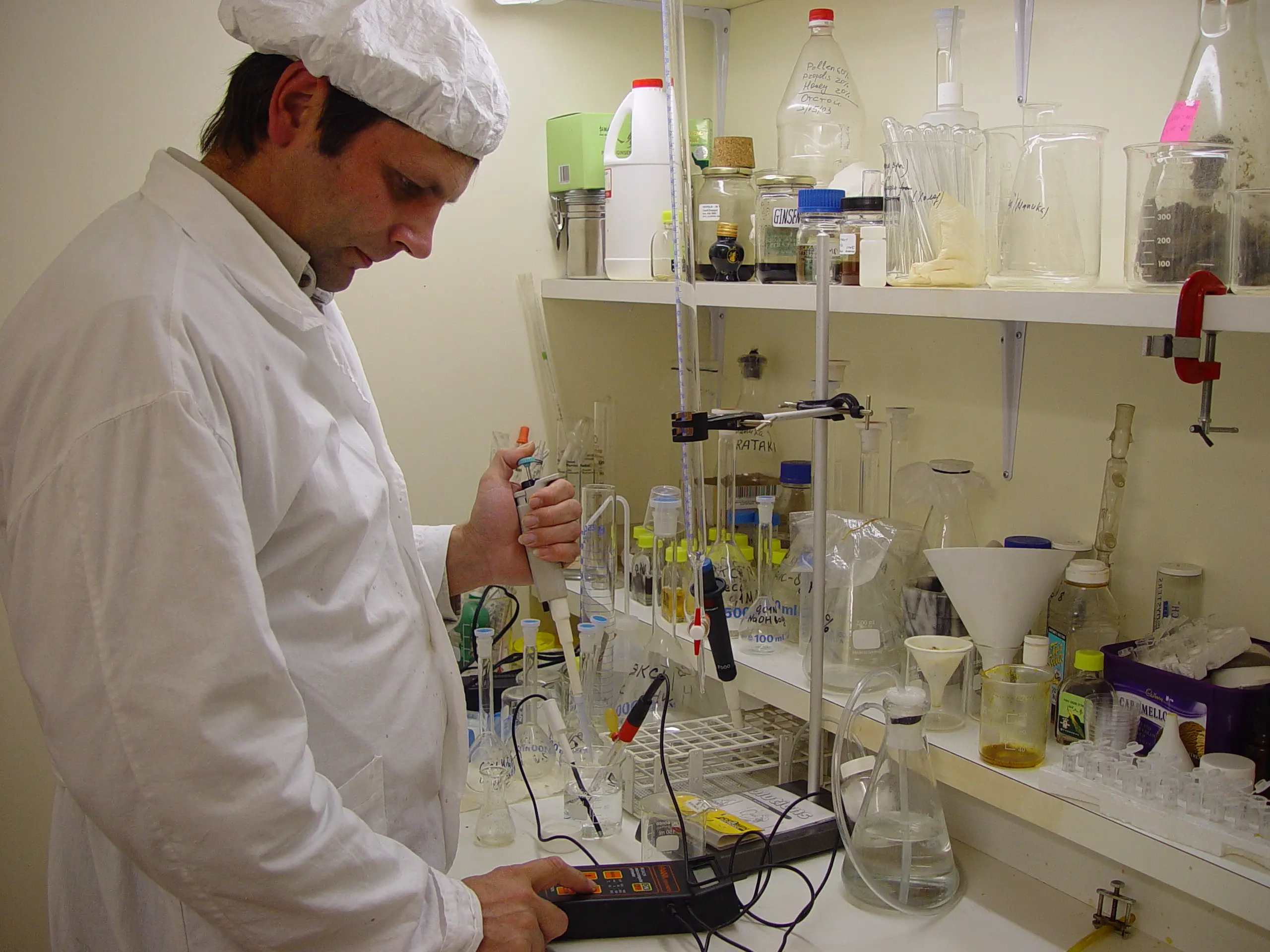 Beekeeper working with hives in New Zealand landscape